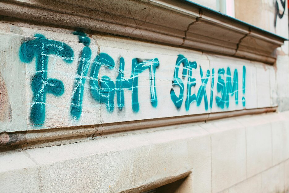 Close-Up eines Schriftzuges auf einer Hauswand, zu lesen ist "Fight Sexism" als Graffito